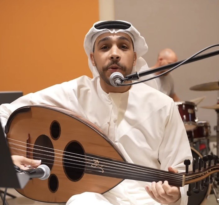 An artist in Abu Dhabi singing and playing the oud